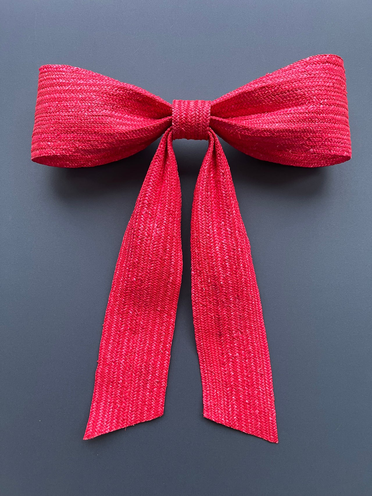 Large decorative red bow made with straw braid