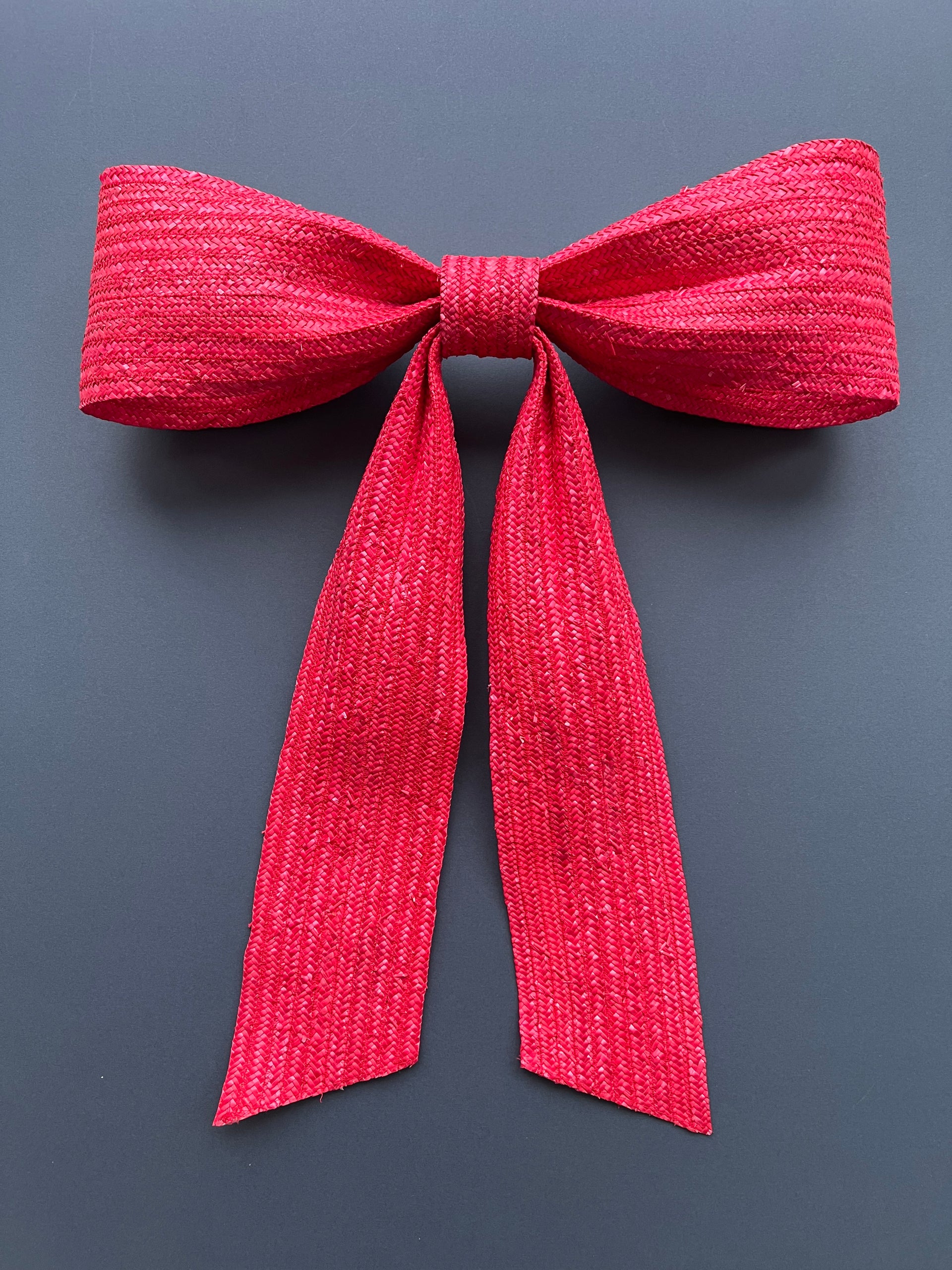 Large decorative red bow made with straw braid