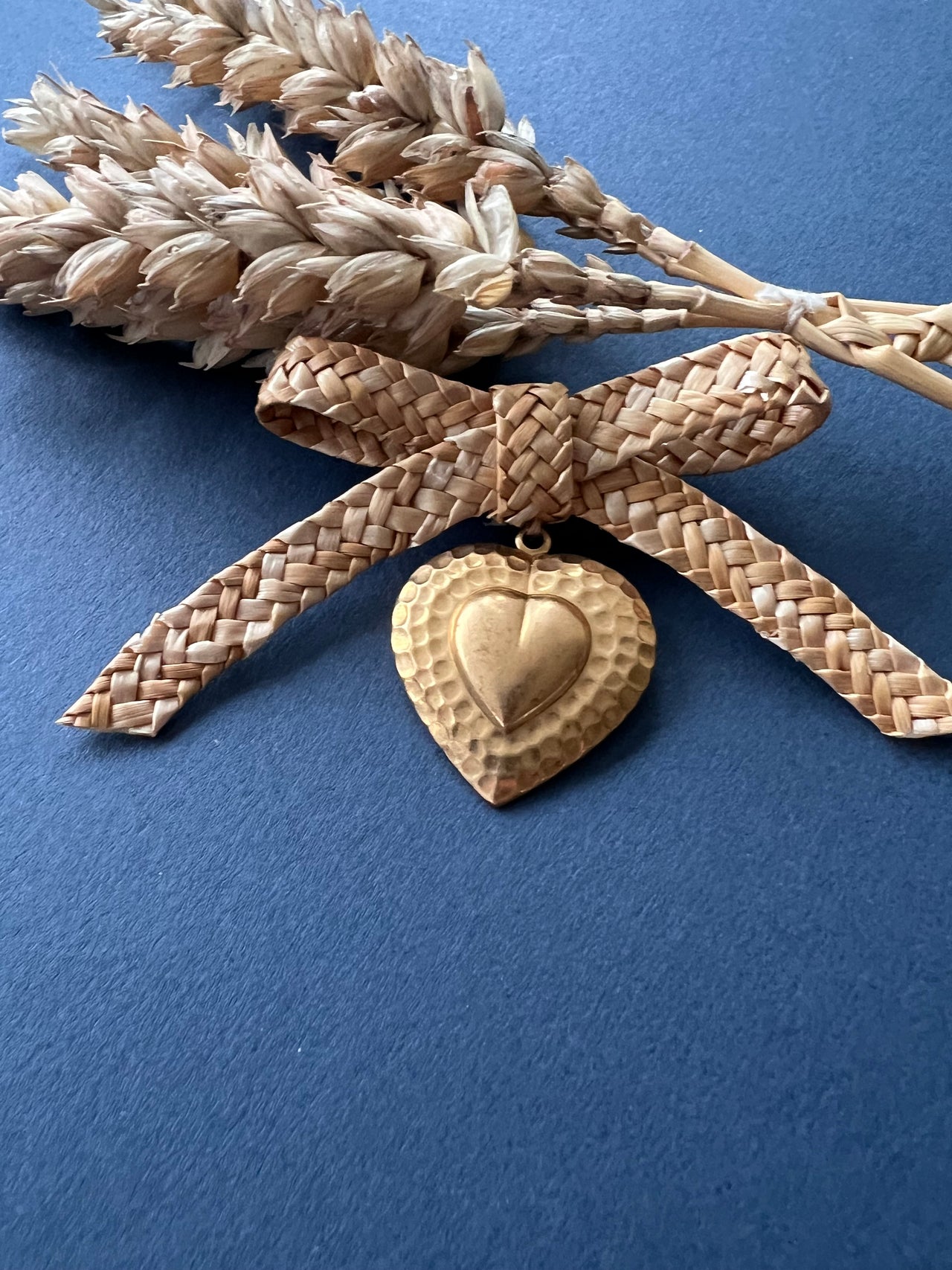 Straw bow brooch with small gold coloured heart