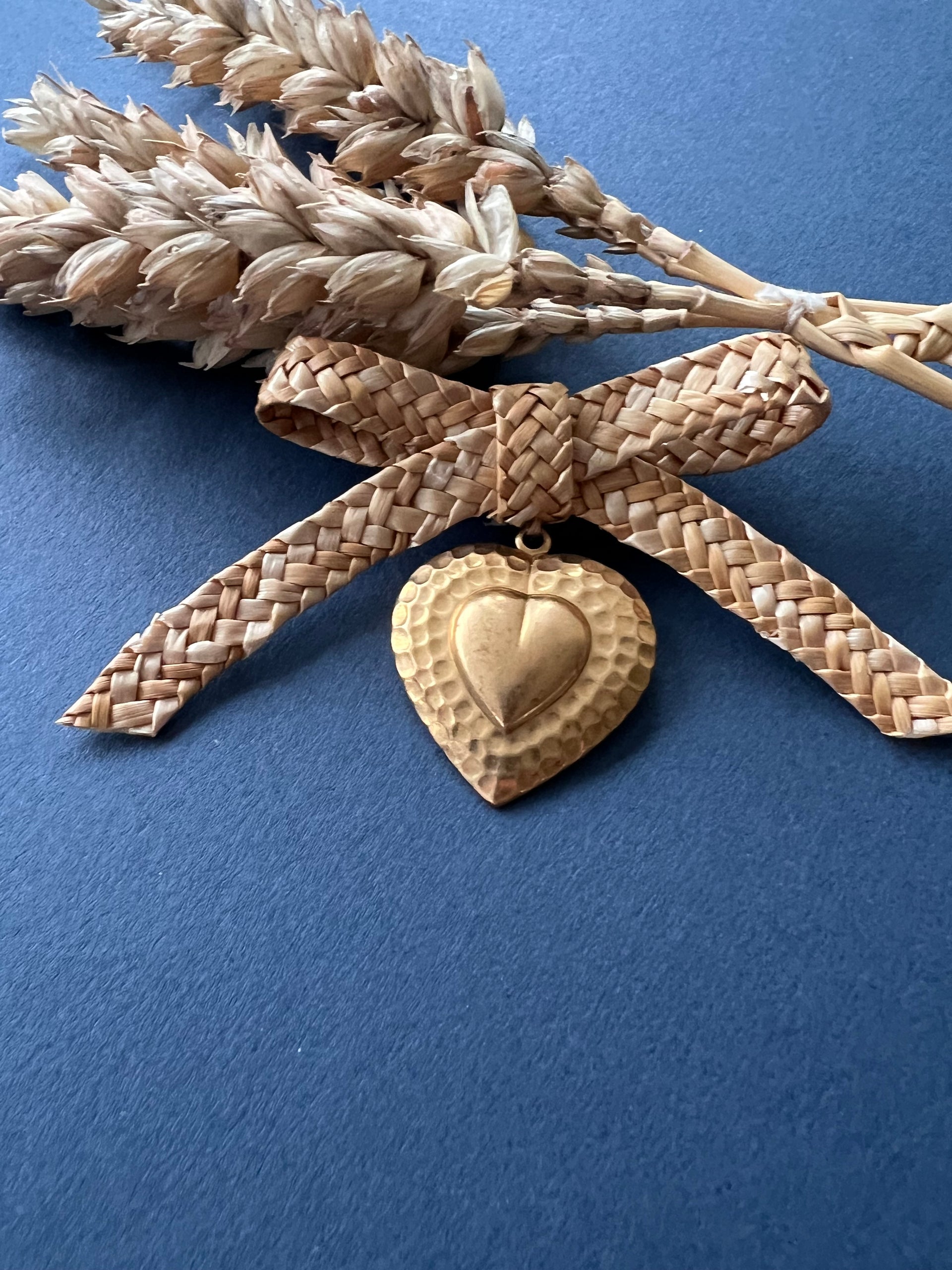 Straw bow brooch with small gold coloured heart