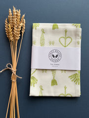 White tea towel with bright green  corn dolly print