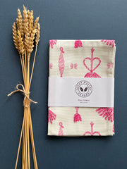 White tea towel with original corn dolly pattern in pink by Penny Maltby